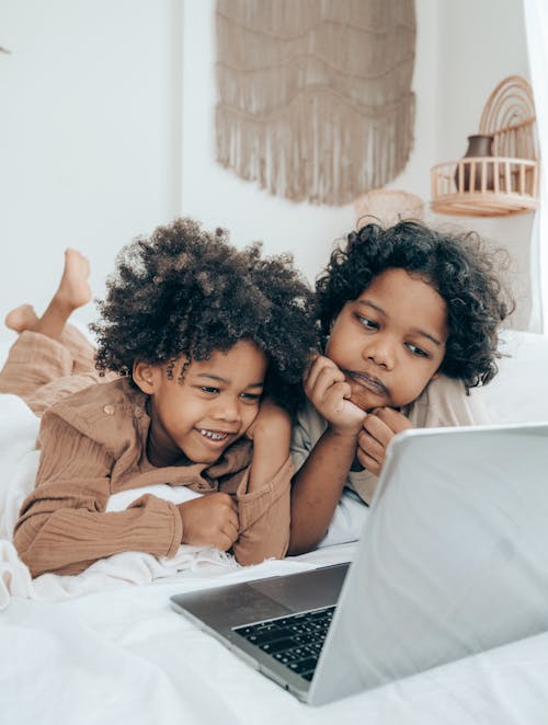 Free Happy and sad black brothers watching video on laptop Stock Photo