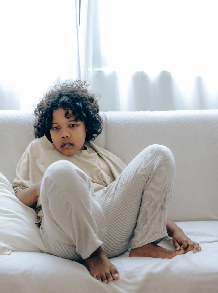 Focused Ethnic Boy Watching TV On Sofa