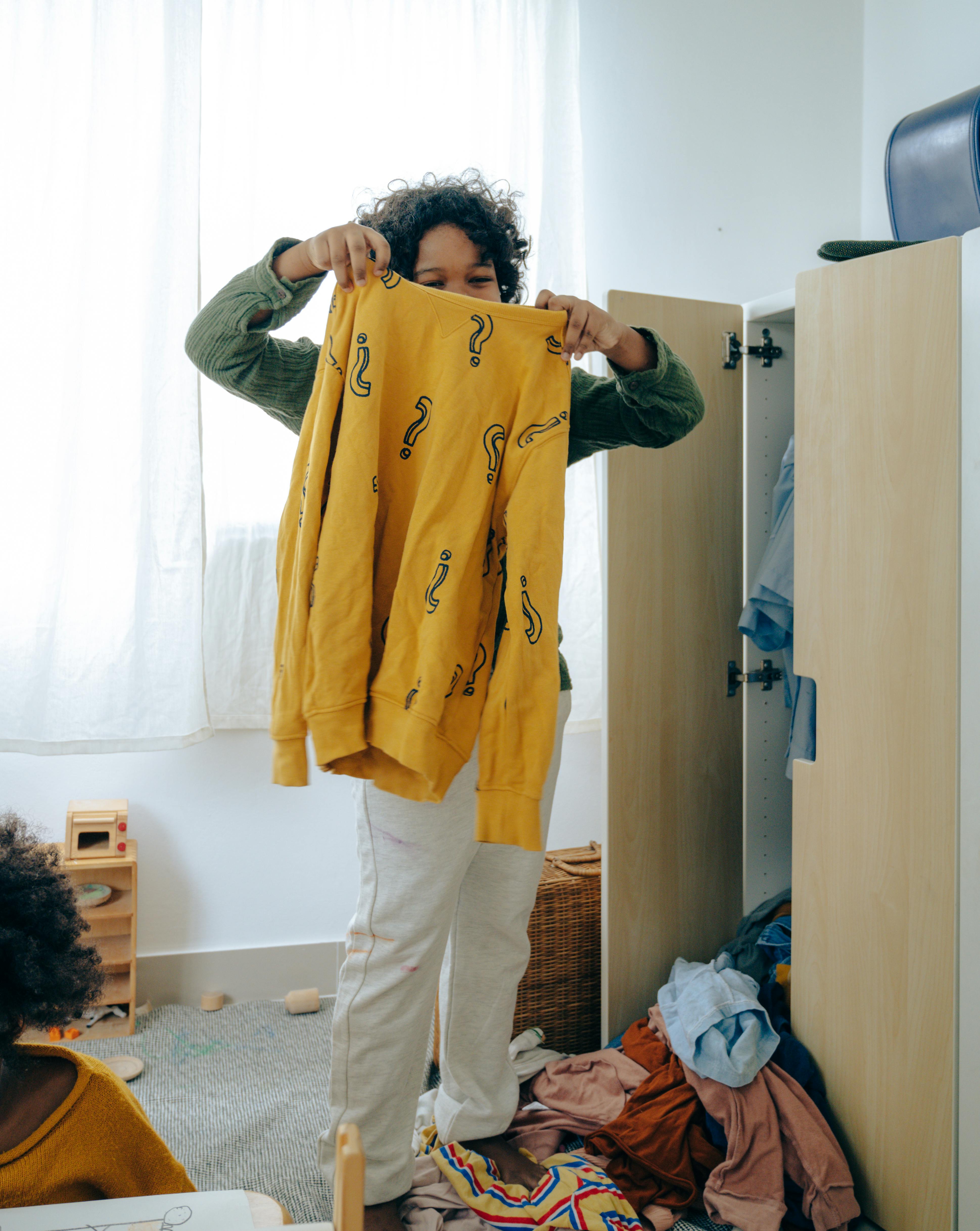 black teenager choosing clothes in bedroom