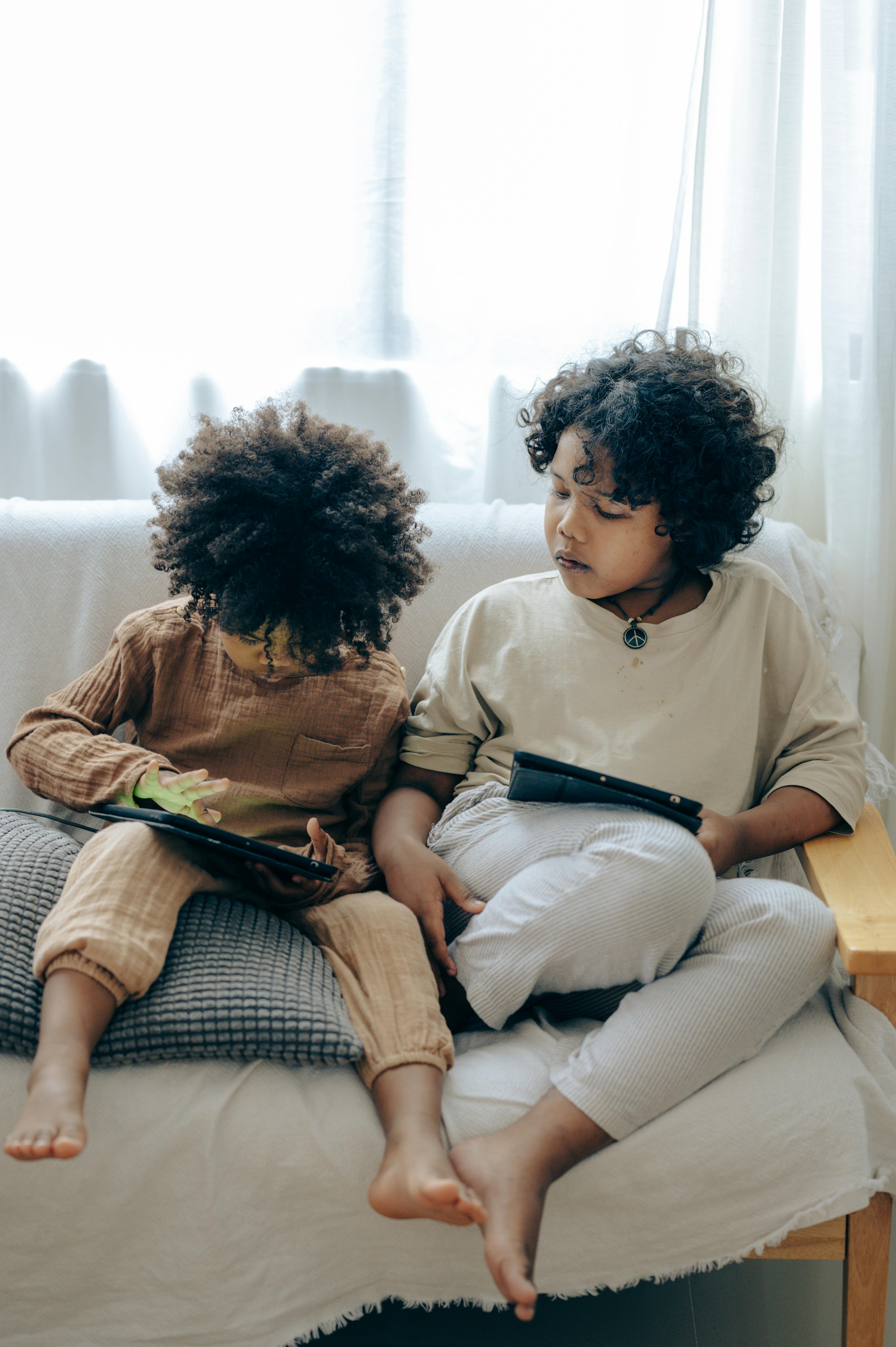 little girls spending time together at home with tablets