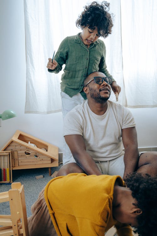 Free Cute black child taking care of dad during game at home Stock Photo