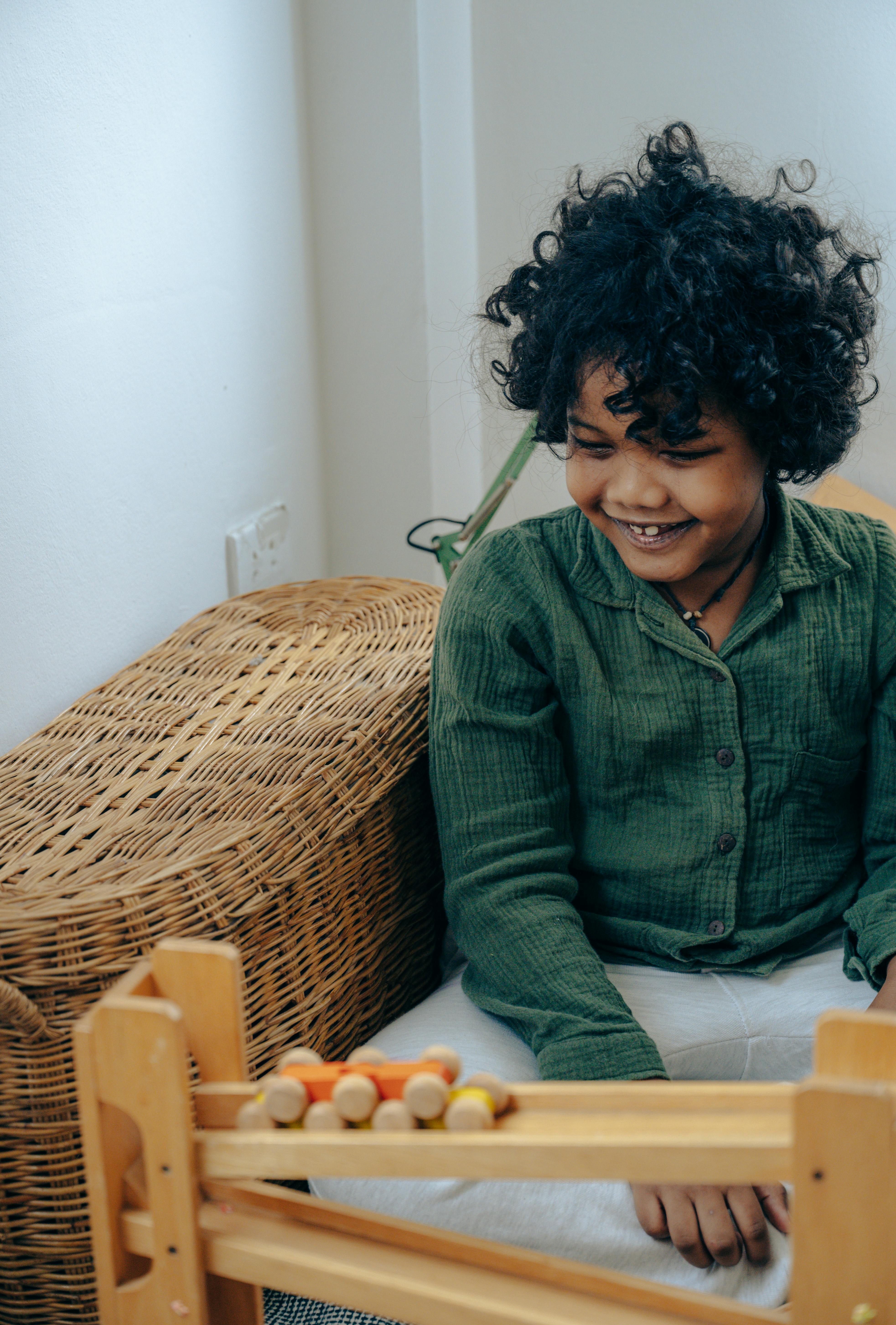 happy kid playing with wooden constructor at home