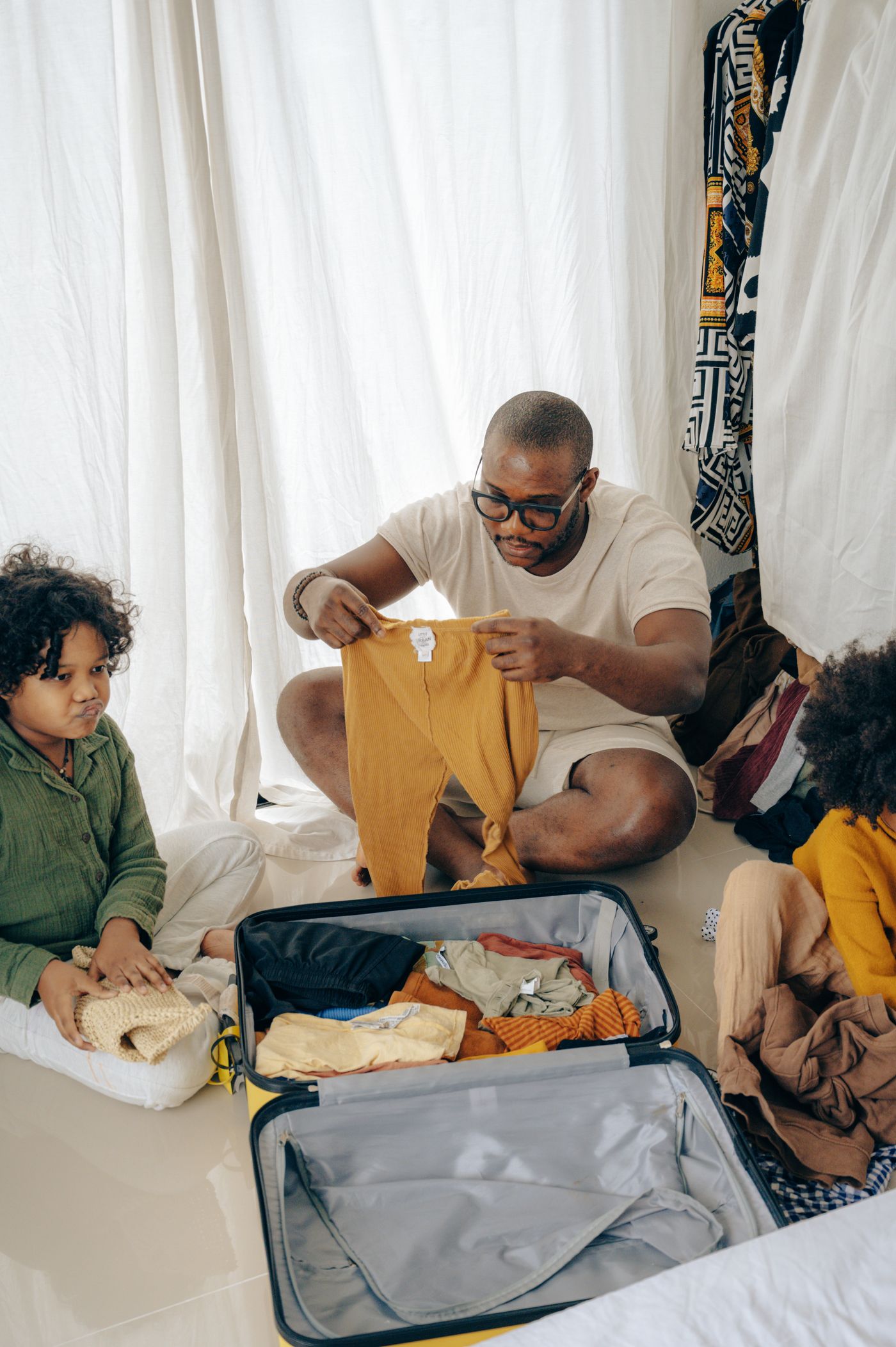 Family sorting clothes beside an open suitcase