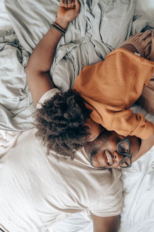 Free A joyful moment of a father and child hugging in bed, expressing love and togetherness. Stock Photo