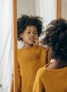 Cute black kid with toothbrush in bathroom