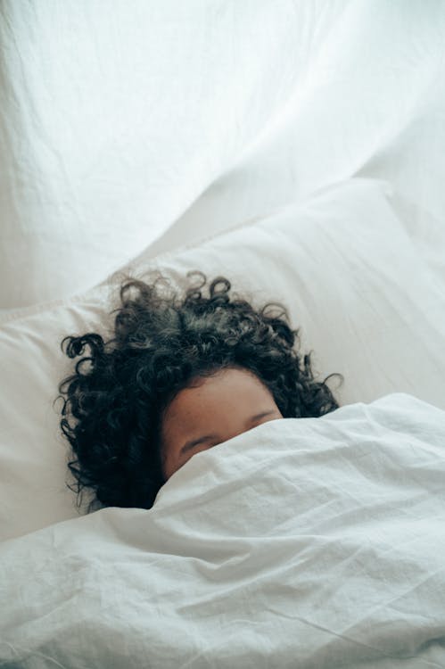 Free Unrecognizable person sleeping under blanket Stock Photo