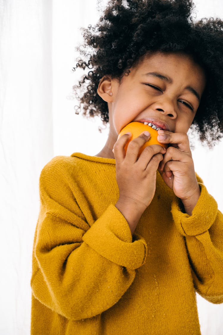 African American Kid Eating Orange