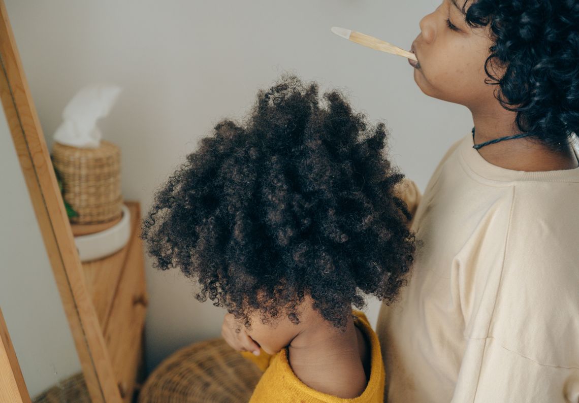 Two children brushing their teeth together in a home bathroom