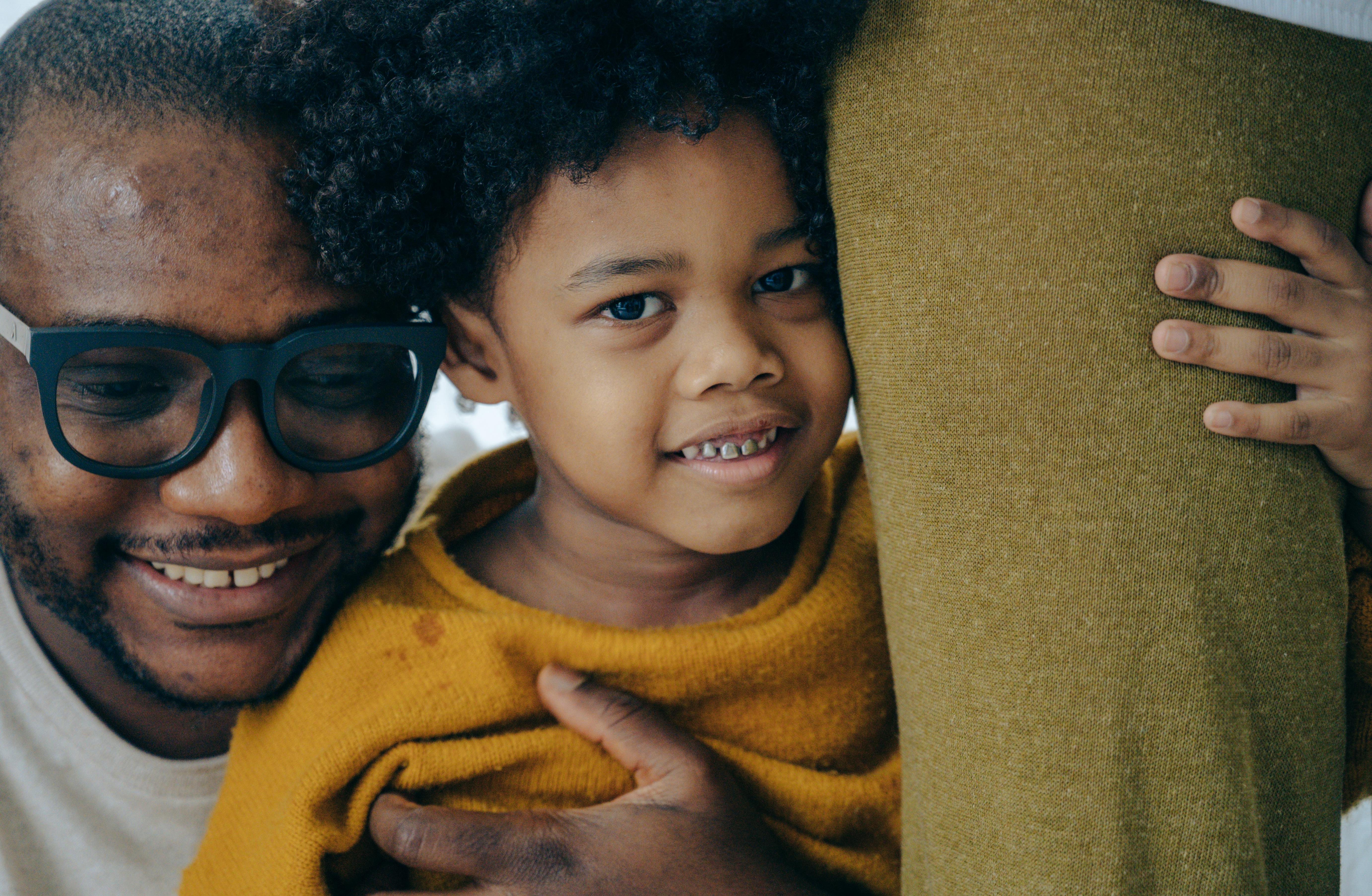 cheerful black father and son hugging