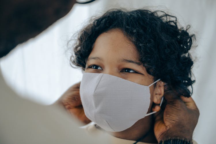 Father Putting On Face Mask On Son