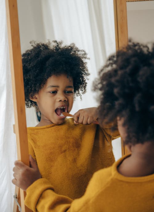 Funny boy brushing teeth in morning