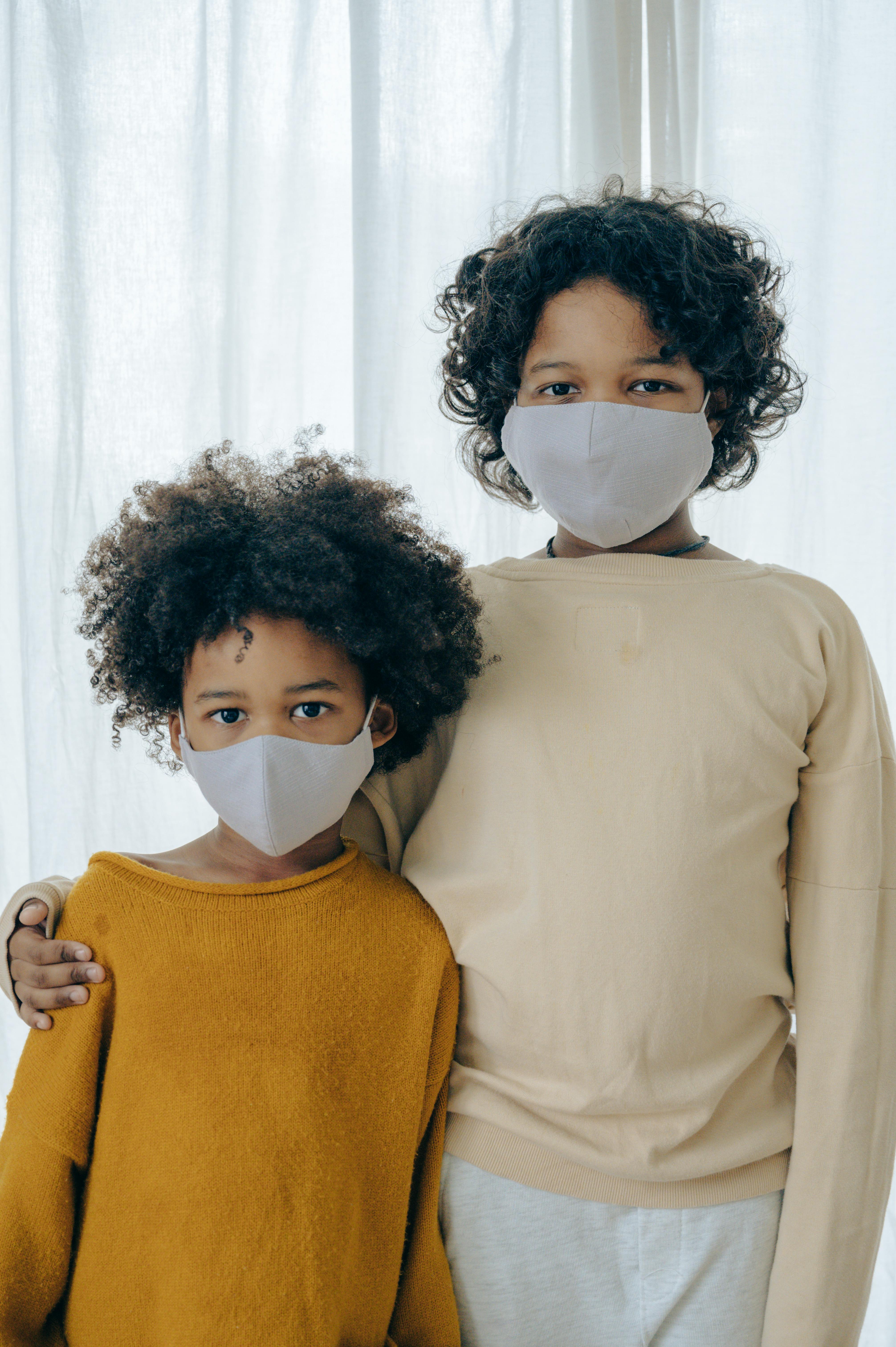 cute positive bonding siblings in face masks