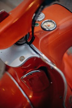 Detailed view of a classic red scooter dashboard with visible gauges.
