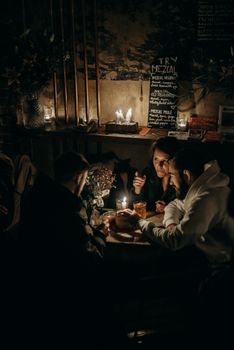 在烛光咖啡馆里，一群朋友享受着温暖的夜晚，非常适合舒适的生活方式主题