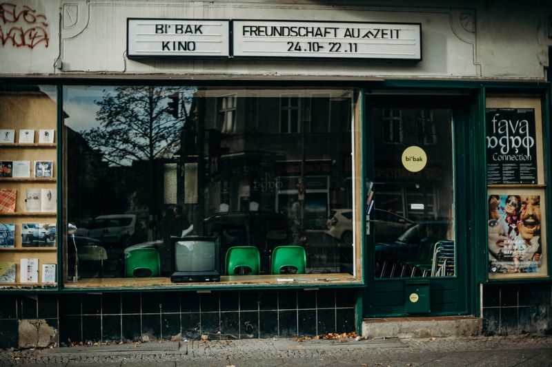 A vintage storefront displaying an old TV, books, and posters, reflecting a nostalgic urban atmosphere.
