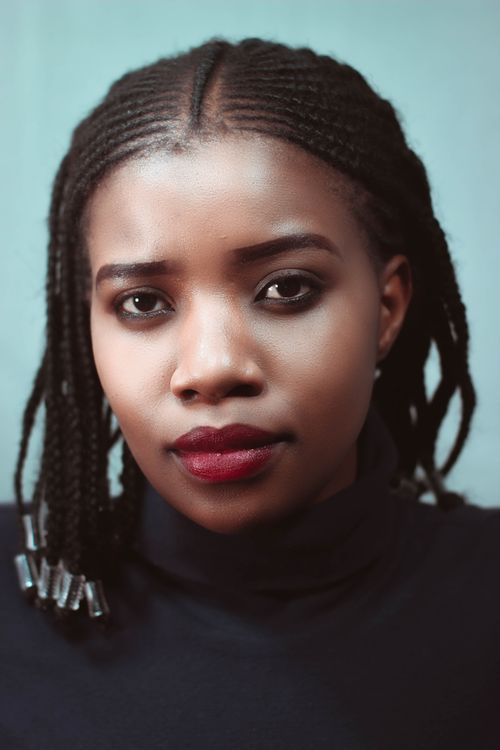 Free Tranquil young African American female with modern hairstyle and makeup looking at camera Stock Photo