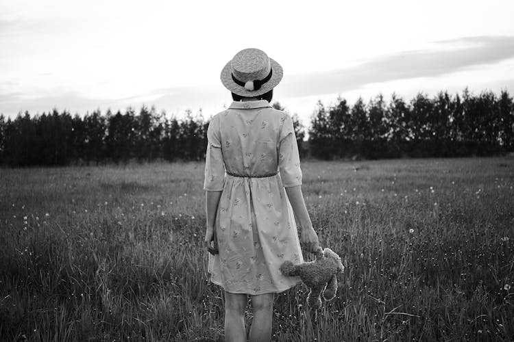 Unrecognizable Woman With Teddy Bear In Field