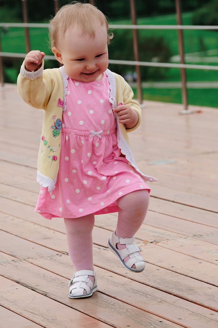 Cheerful Toddler Walking On Wooden Playground