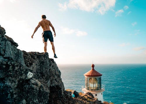 A Shirtless Man on a Rocky Cliff