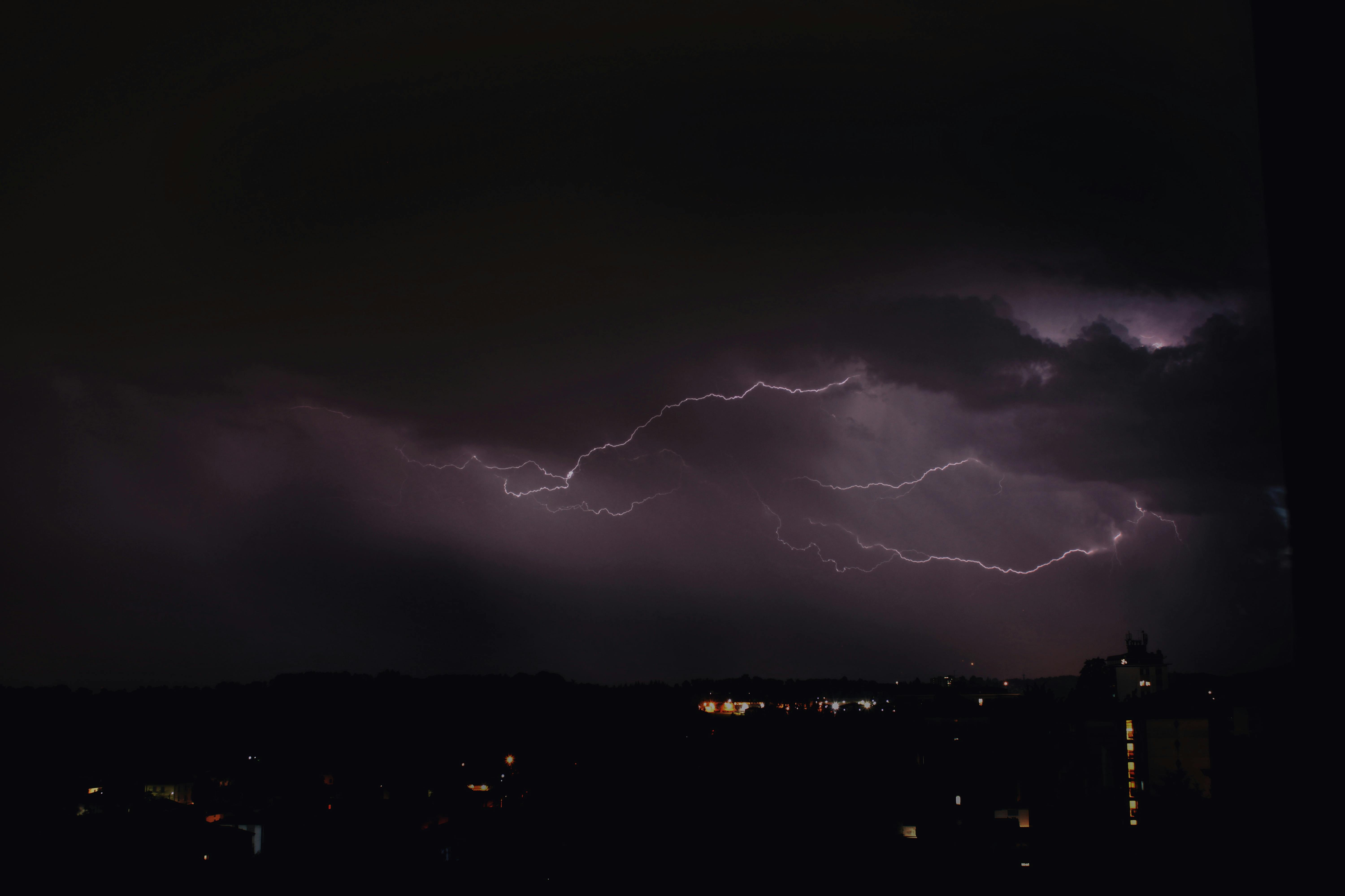 glowing lightning over dark city at night