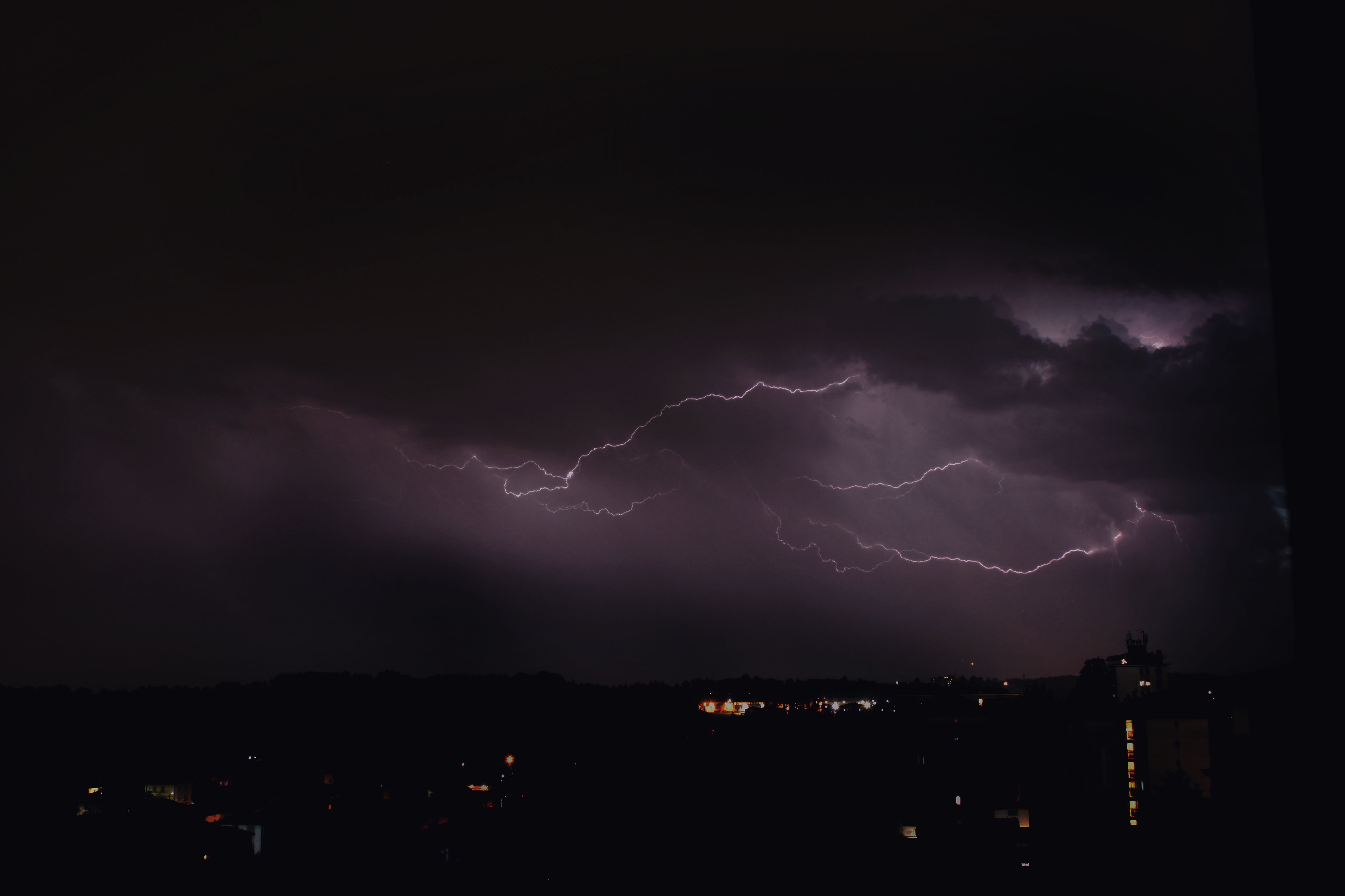 Glowing lightning over dark city at night · Free Stock Photo