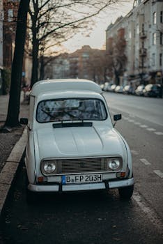 A classic white car parked on a city street in Berlin, showcasing urban life.