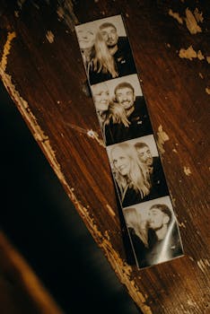 A black and white photobooth strip on a rustic wood surface, evoking nostalgia.