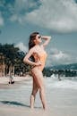 Woman in Brown and White Floral Bikini Standing on Beach