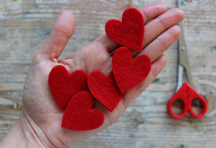 A Hand Holding Cut Outs Artificial Hearts