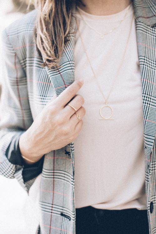 Free Close-up shot of a person wearing jewelry and a plaid blazer. Stock Photo
