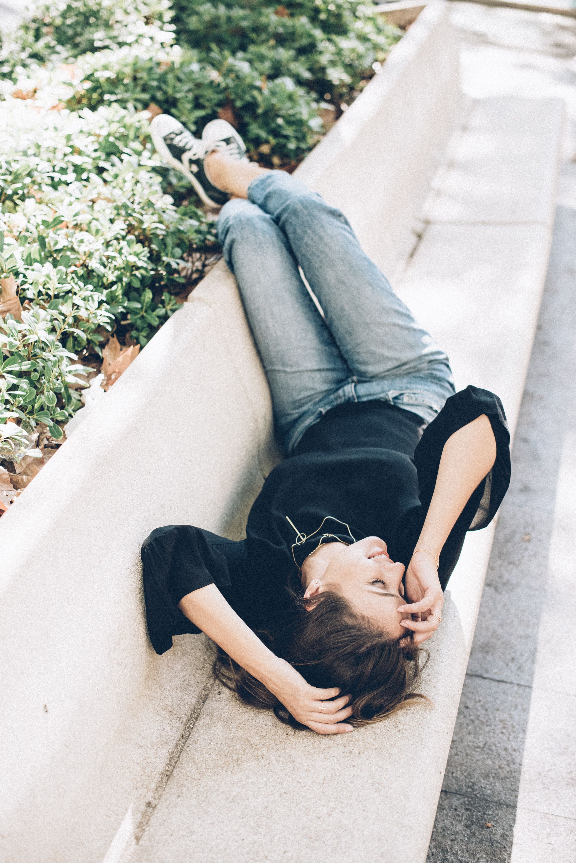 A Woman Lying Down on a Concrete Bench · Free Stock Photo