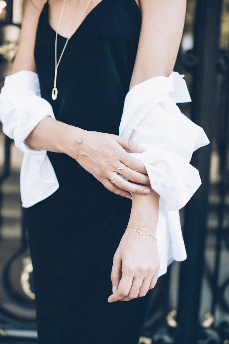 
A Woman Wearing A Black Dress And Gold Accessories