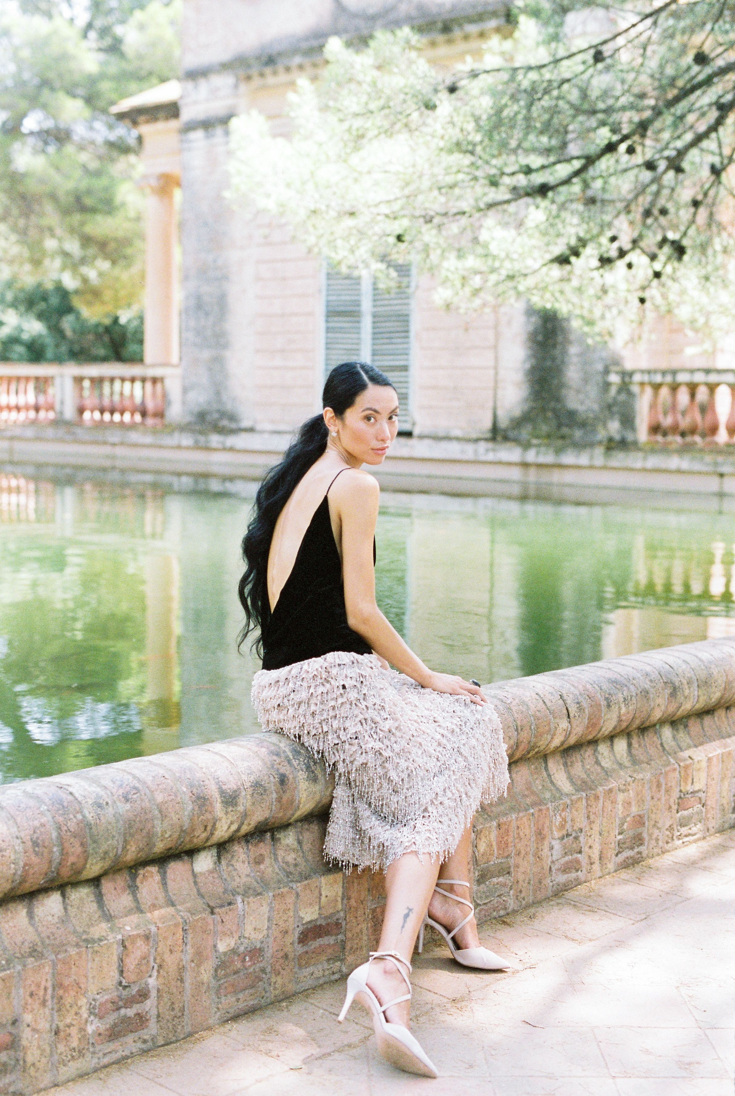 A Beautiful Woman in Black Tank Top Sitting on Concrete Railing while ...