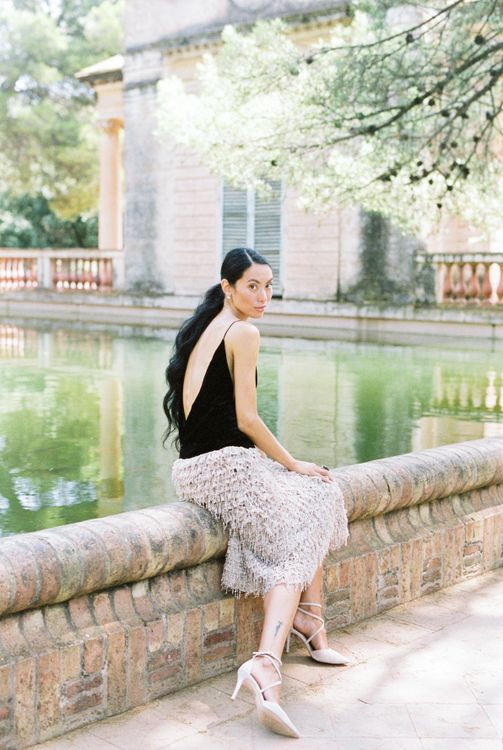 A Beautiful Woman in Black Tank Top Sitting on Concrete Railing while ...