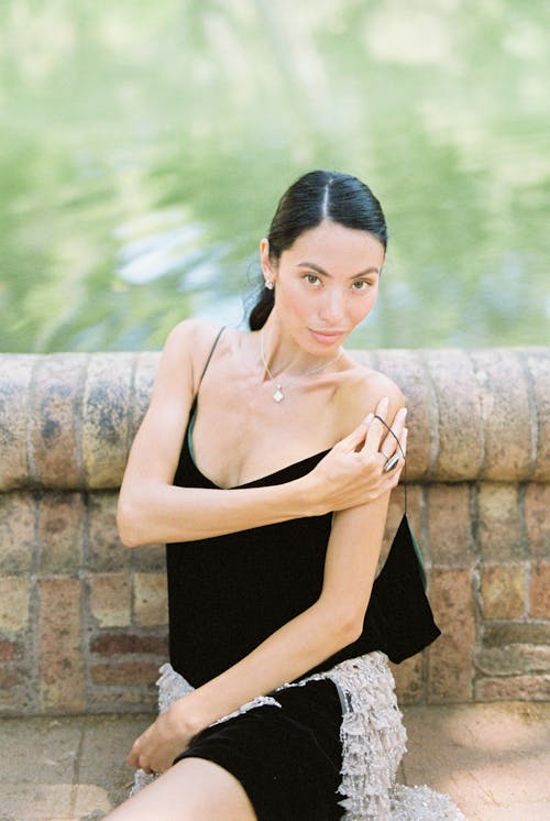 A Woman in Black Spaghetti Strap Dress Sitting on the Floor