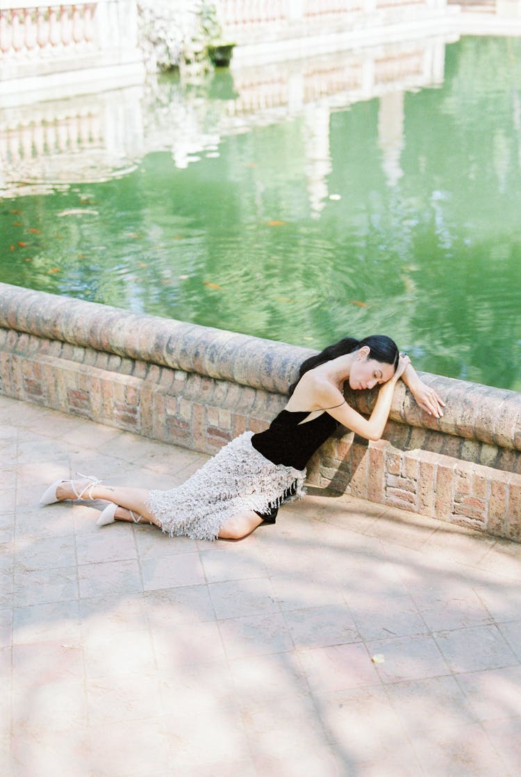 Woman In Dress Sleeping Near Body Of Water 