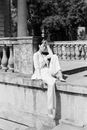 Woman in White Robe Sitting on Concrete Bench