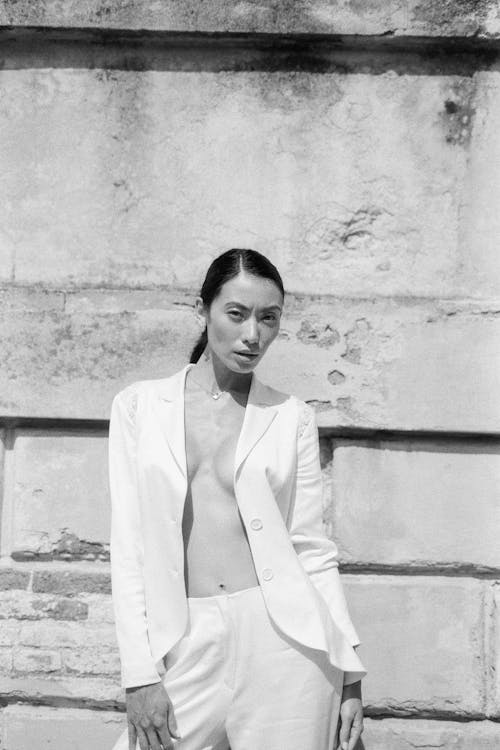 Woman in White Blazer Standing Near Wall