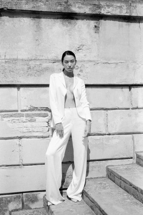 Femme En Blazer Blanc Et Pantalon Debout Sur Des Escaliers En Béton