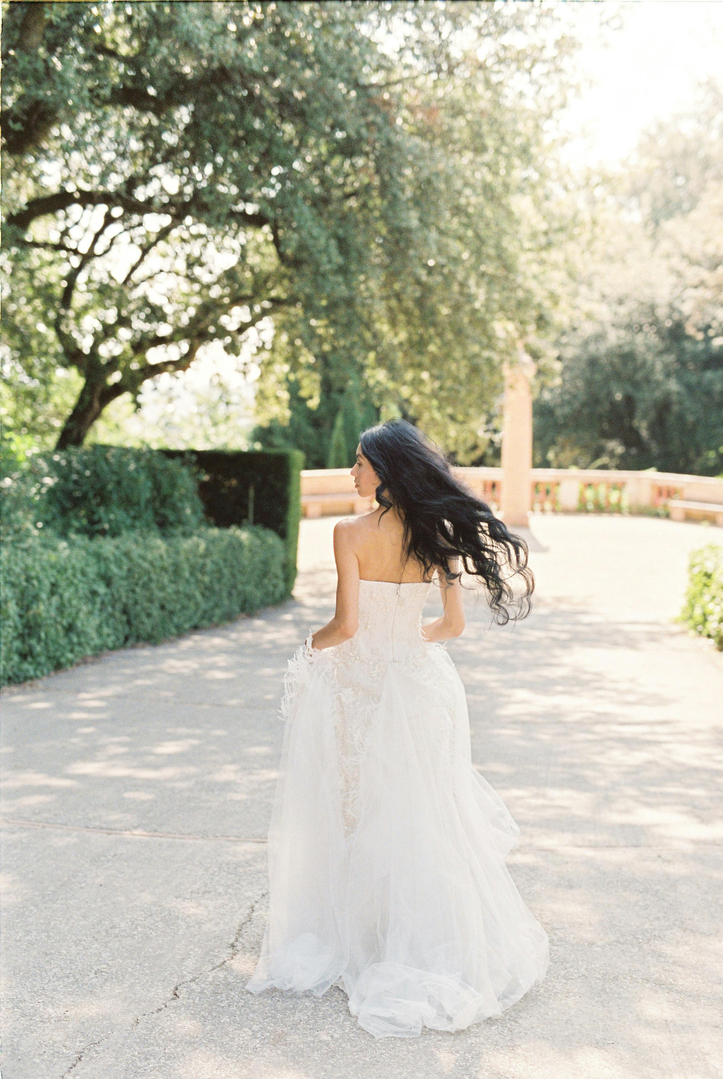 a woman in white dress walking on road