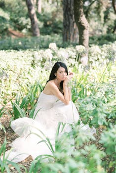 郁郁葱葱的花园里，一位美丽的新娘坐在绿叶和柔和的阳光中