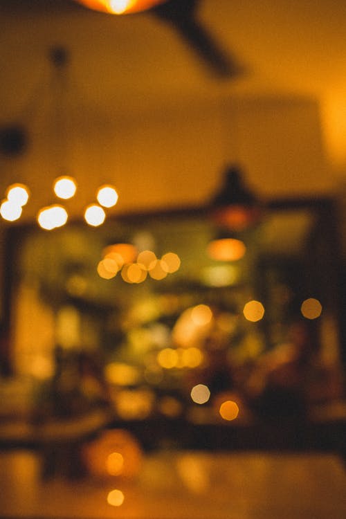 Ánh sáng nhân tạo mờ ở quán cà phê vào ban đêm tạo không gian ấm cúng và lãng mạn. Hãy xem hình ảnh liên quan để cảm nhận và đắm chìm trong không gian đó. 