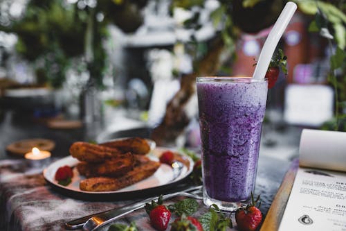 Free Delicious churros with fresh strawberries and blueberry smoothie in cafe Stock Photo