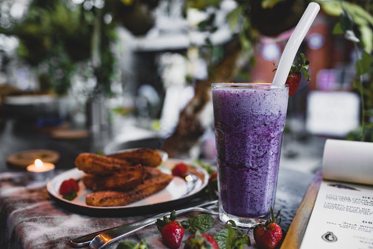 Delicious Churros With Fresh Strawberries And Blueberry Smoothie In Cafe