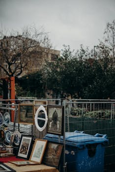 Explore a diverse array of vintage paintings and prints at an outdoor flea market