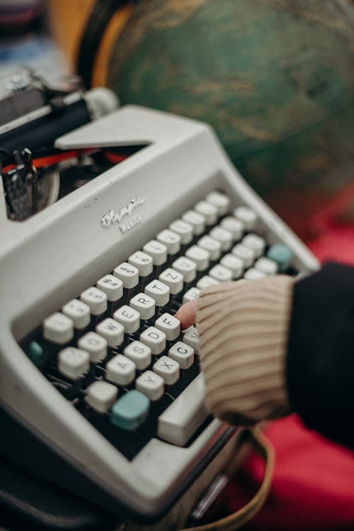 Person Holding Gray and Black Typewriter