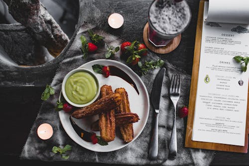 Free Churro with avocado sauce and lavender dessert served on table Stock Photo