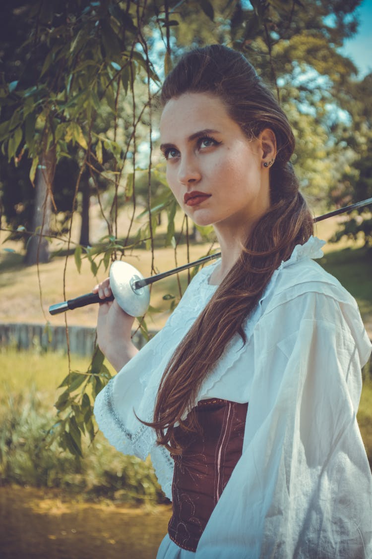 Serious Young Lady In Vintage Costume With Fencing Sword In Hand