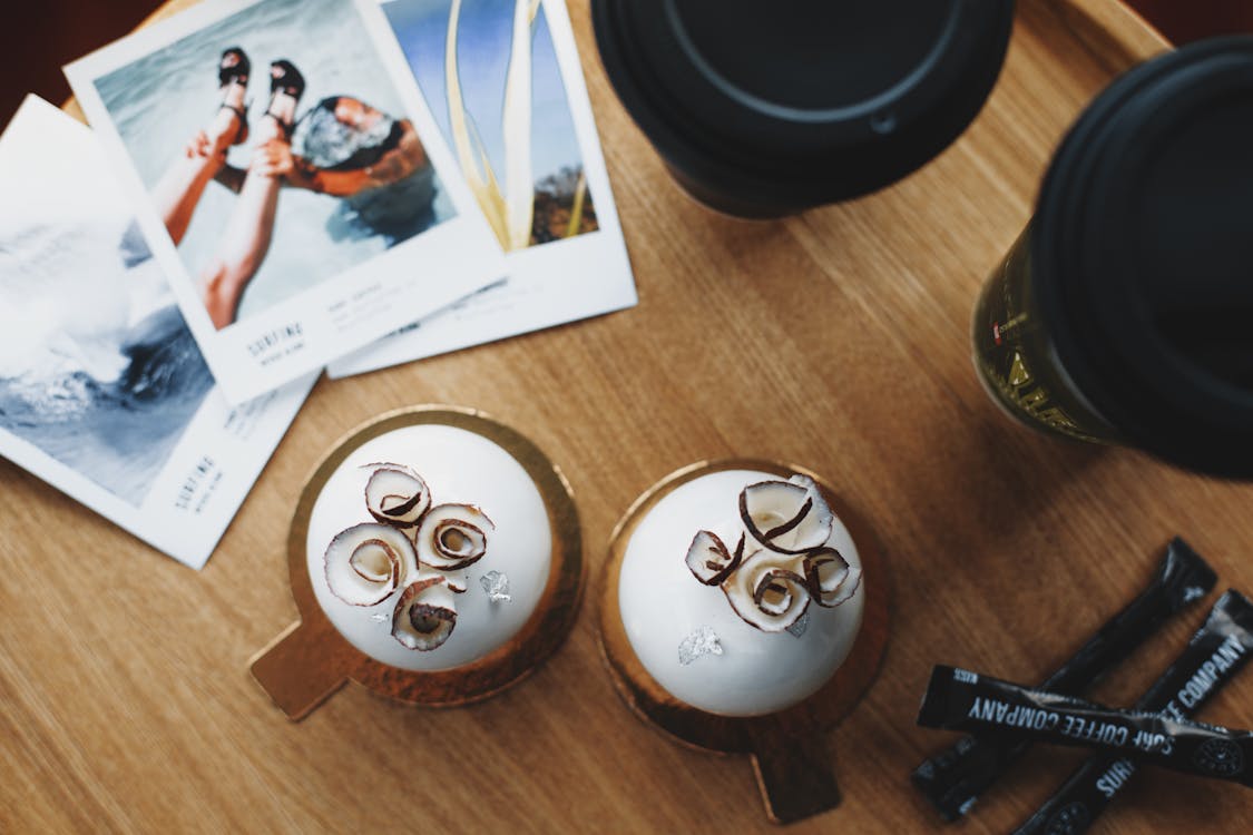 Free Coconut sweets and takeaway coffee on table of modern cafe Stock Photo