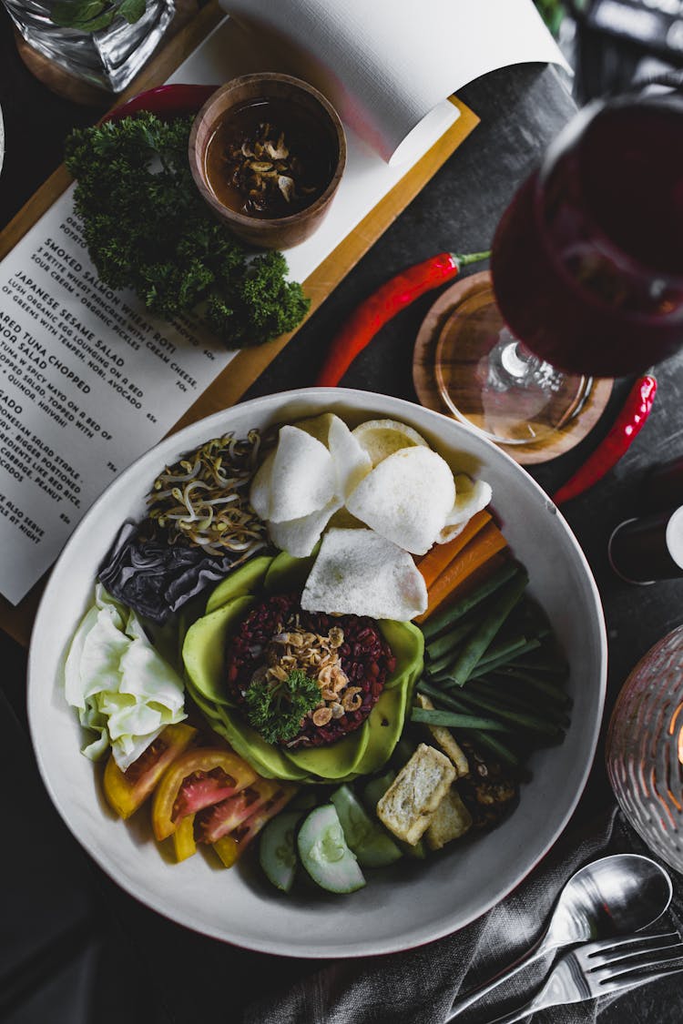 Healthy Salad Bowl Served With Sauce And Glass Of Wine In Cozy Cafe